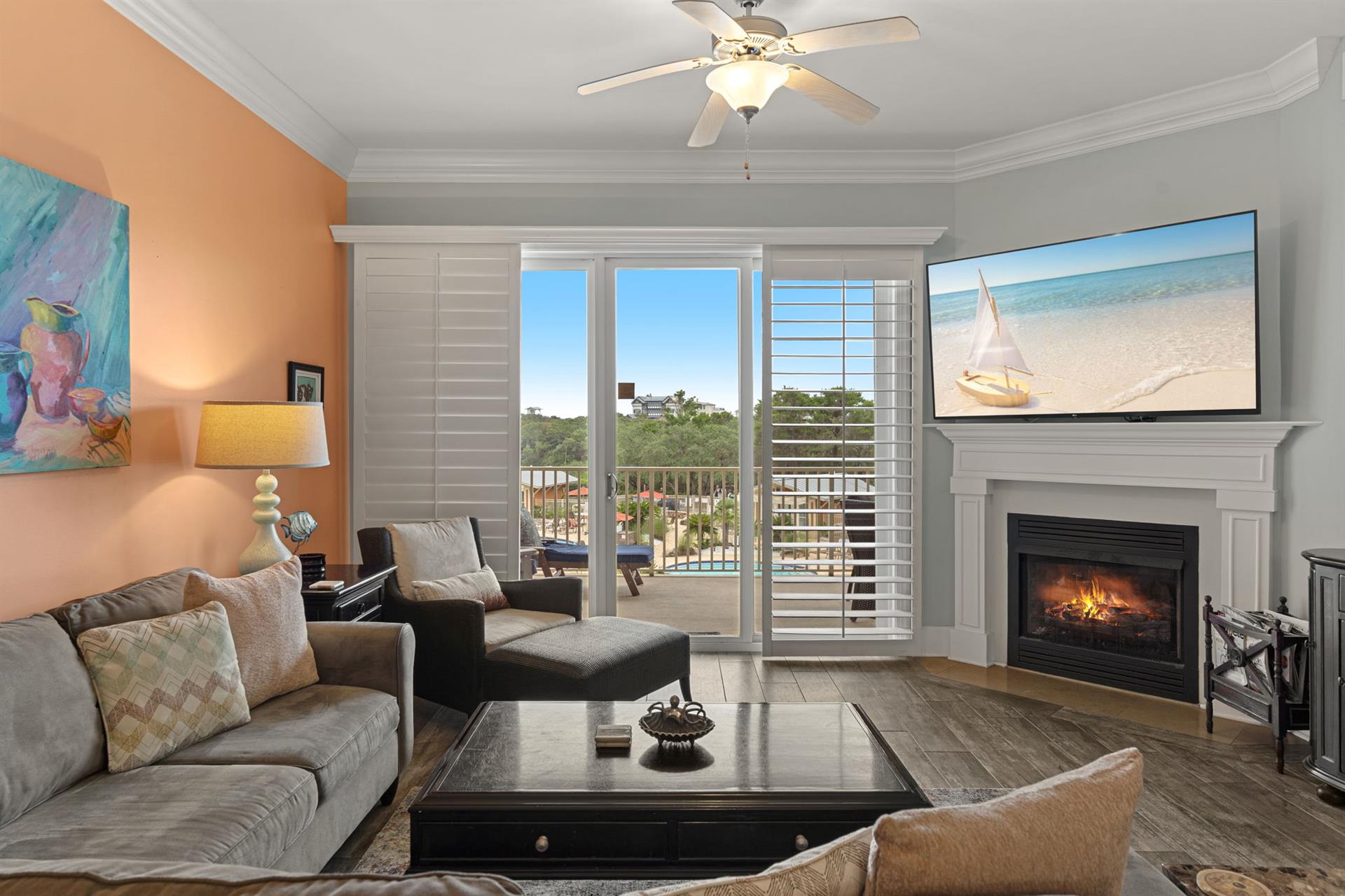 Unwind in the cozy living room, where plush seating, a warm fireplace, and balcony access create the perfect retreat for relaxing after beach adventures.