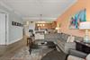 Spacious living area with sectional, enjoy vibrant coastal art, and let the open layout connect you to the fullyequipped kitchen.