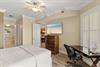 Peaceful king bedroom retreat features a plush bed, ceiling fan for comfort, and elegant coastal artwork that sets the tone for your relaxing getaway.