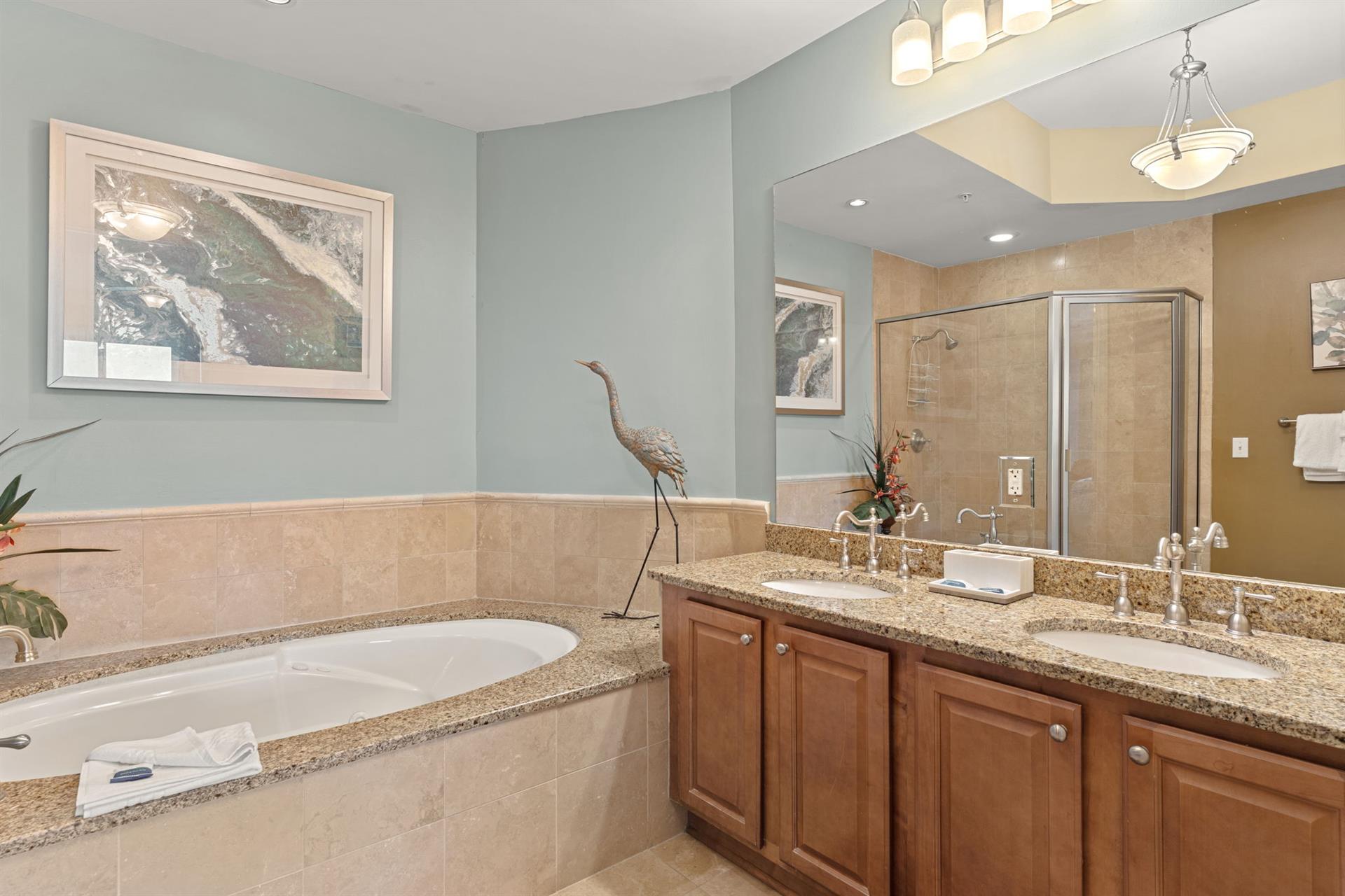 Private spalike bathroom features a soaking tub, walkin shower, dual vanity, and elegant coastal decor. Perfect for relaxing after a day exploring.