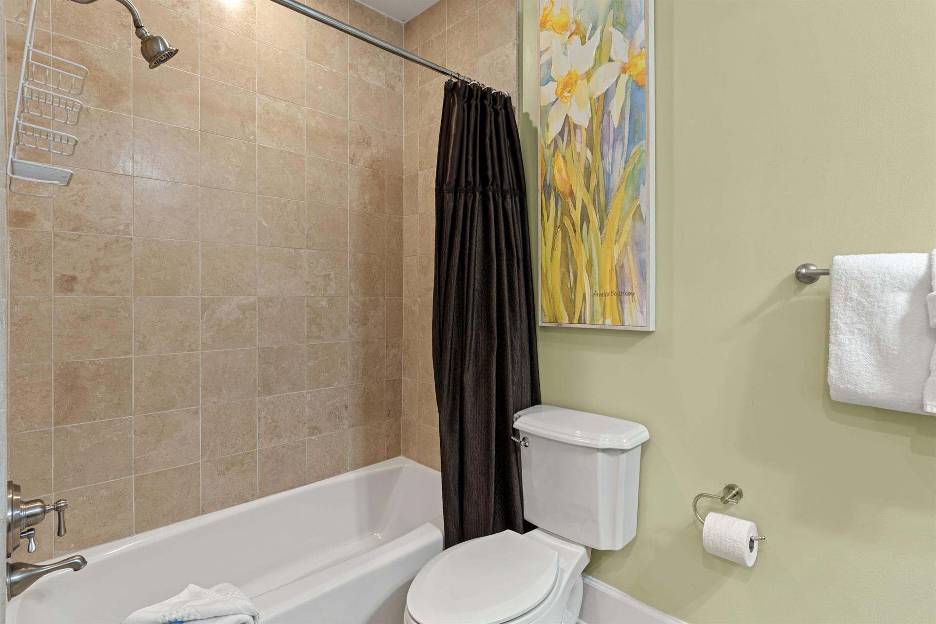 Private guest onsuite, with tub and shower combo and cool coastal tones.