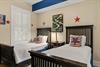 Rest easy in this cheerful room featuring two twin beds dressed in crisp linens, playful red star accents, and colorful artwork that adds a touch of fun to your home away from home.