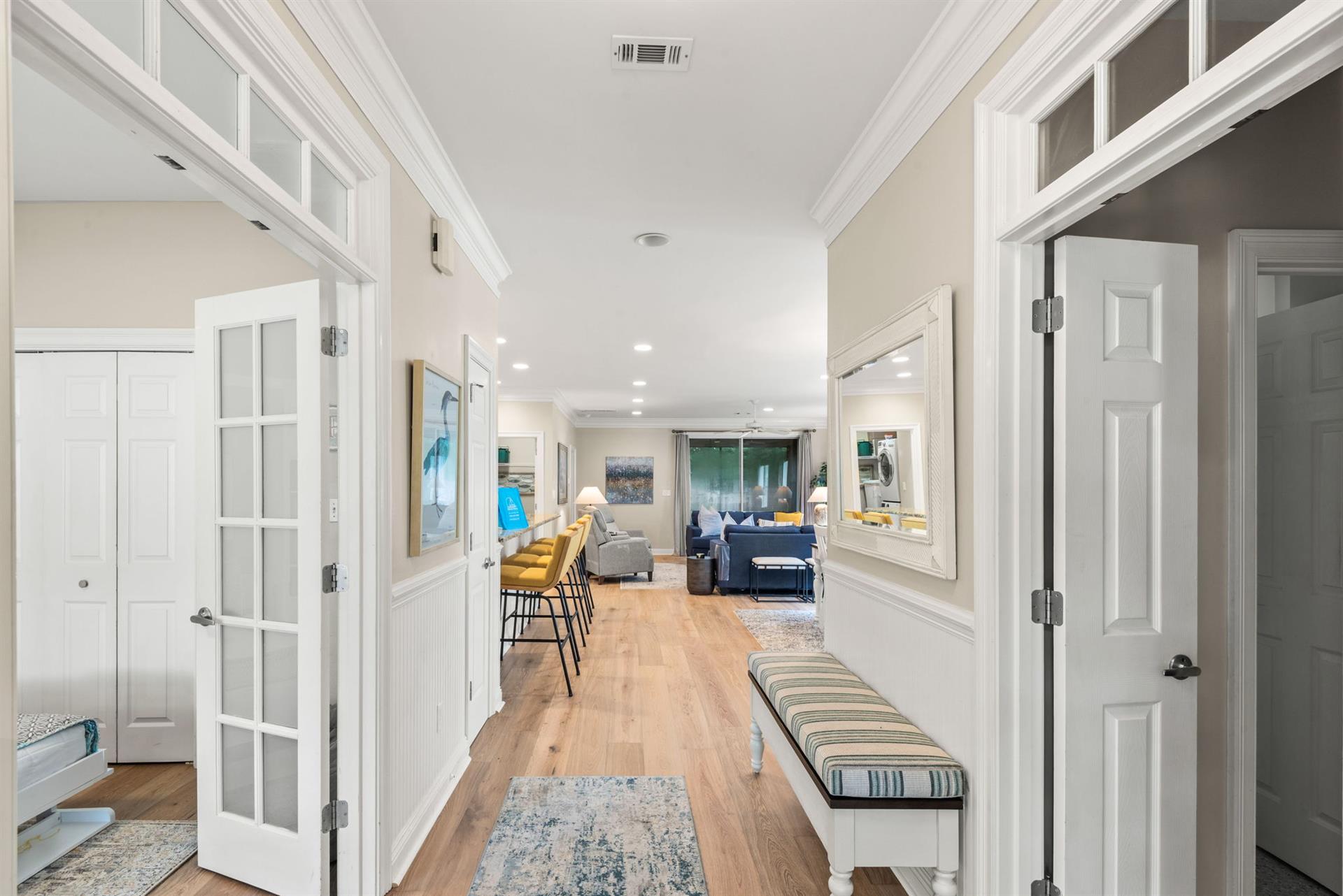 Step into this beautifully designed hallway with warm wood floors and elegant white trim that flows into your spacious living area.