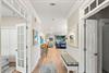 Step into this beautifully designed hallway with warm wood floors and elegant white trim that flows into your spacious living area.