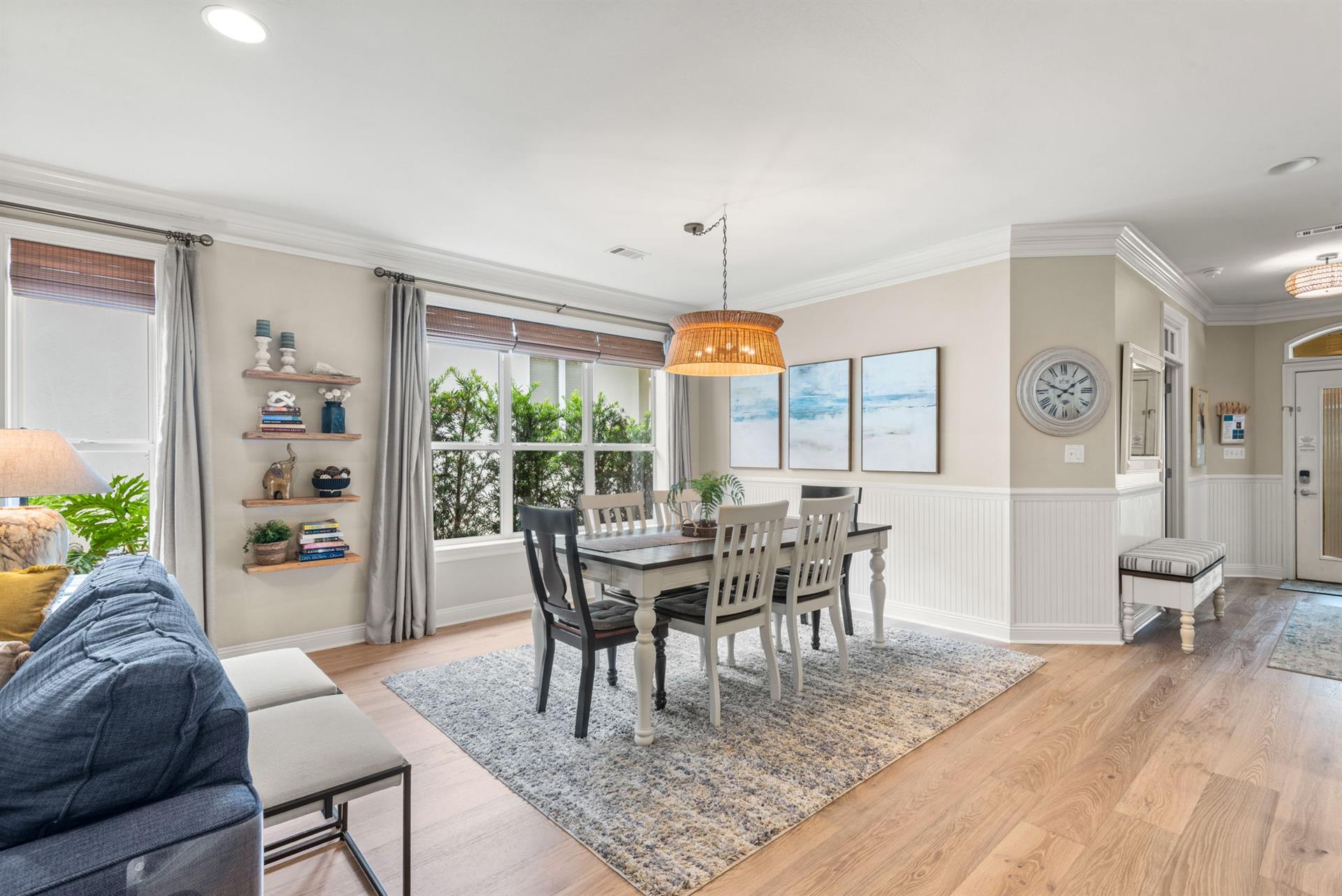 The openconcept dining area blends seamlessly with cozy living space, featuring coastal artwork, natural light, and room to gather around the table for memorable meals together.