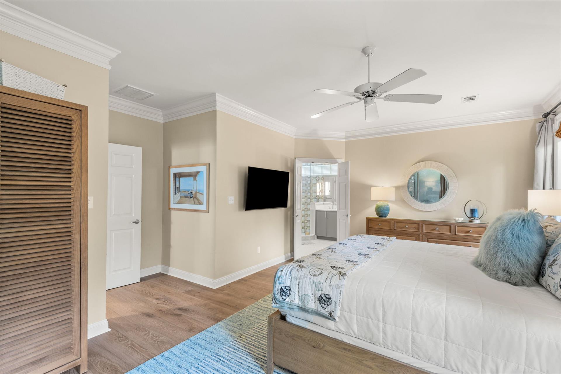 Relax in the primary bedroom with soothing coastal tones, soft linens, and warm wood floors.
