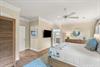 Relax in the primary bedroom with soothing coastal tones, soft linens, and warm wood floors.