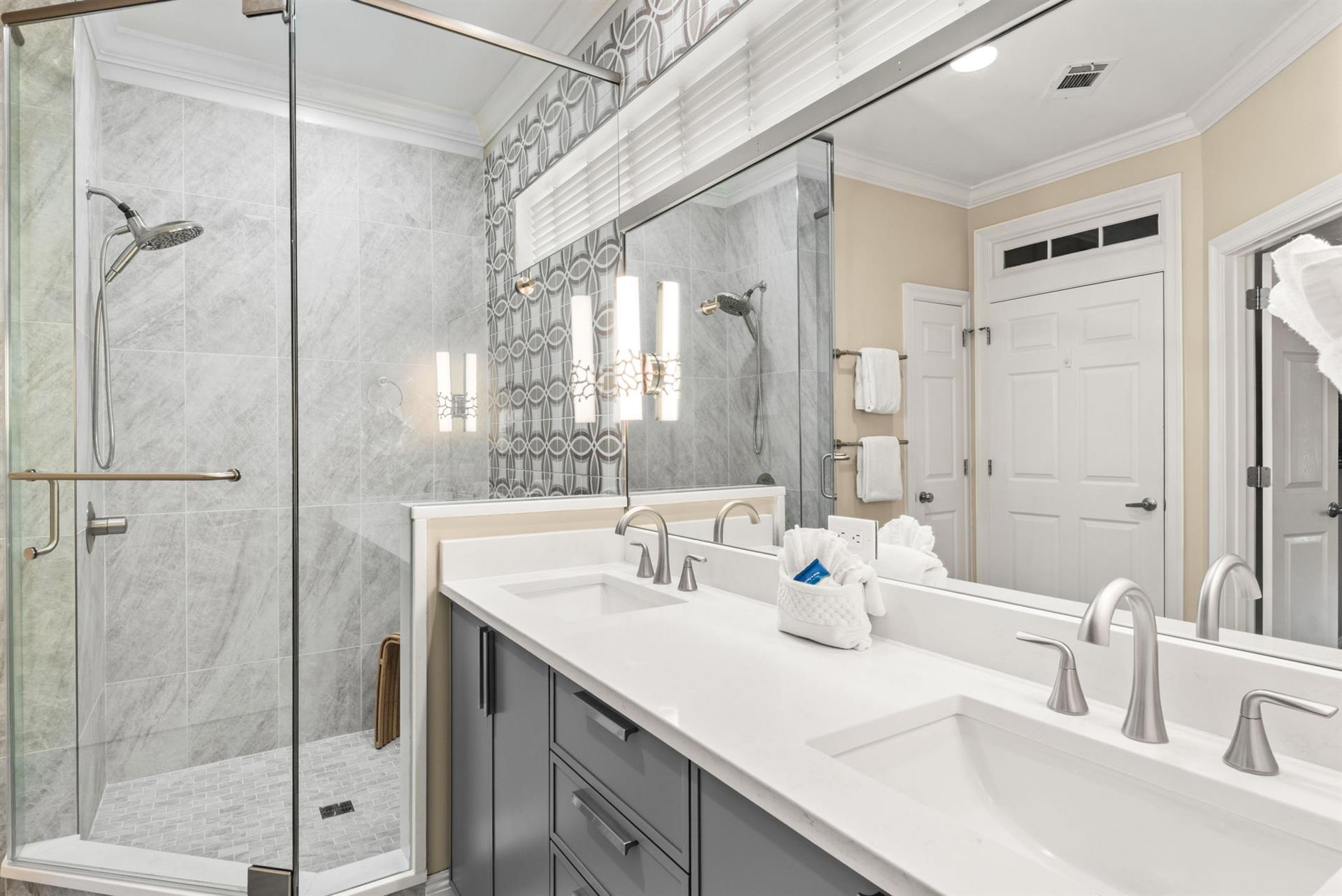 Step into the bright, elegant ensuite bathroom where marble accents and dual sinks give you ample space to refresh.