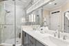 Step into the bright, elegant ensuite bathroom where marble accents and dual sinks give you ample space to refresh.