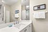 Freshen up in the bathroom, complete with a vanity sink, gleaming countertops, and plush white towels,