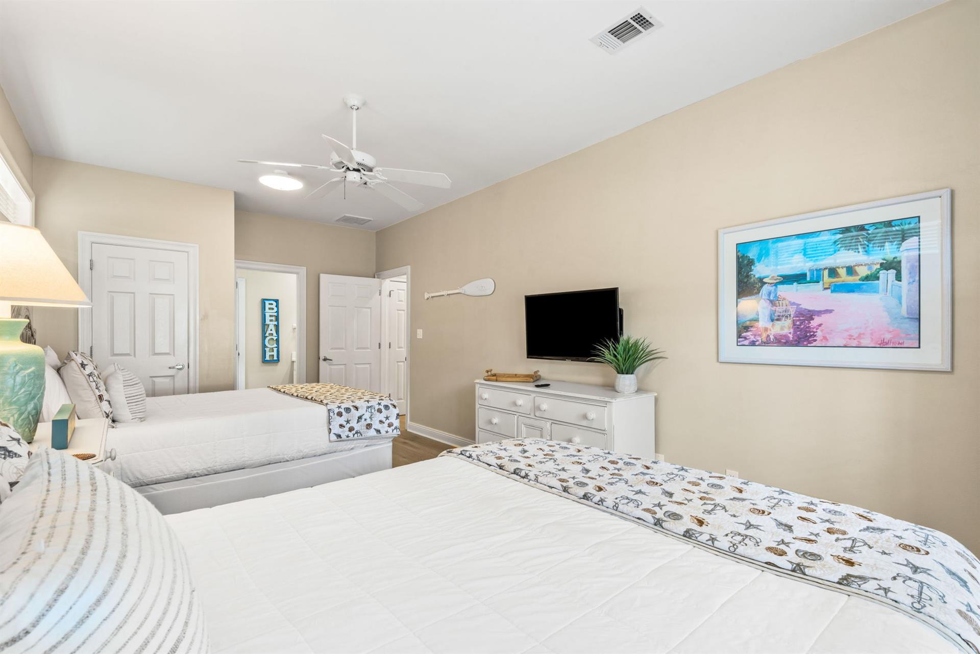 Along with two queen beds, enjoy modern comforts like a flatscreen TV, ceiling fan, and peaceful beachthemed décor.