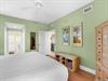 The bedroom with calming coastal hues and tropical artwork.