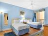 This coastalthemed retreat features two comfy twin beds with crisp white linens, and a soothing ceiling fan breeze.