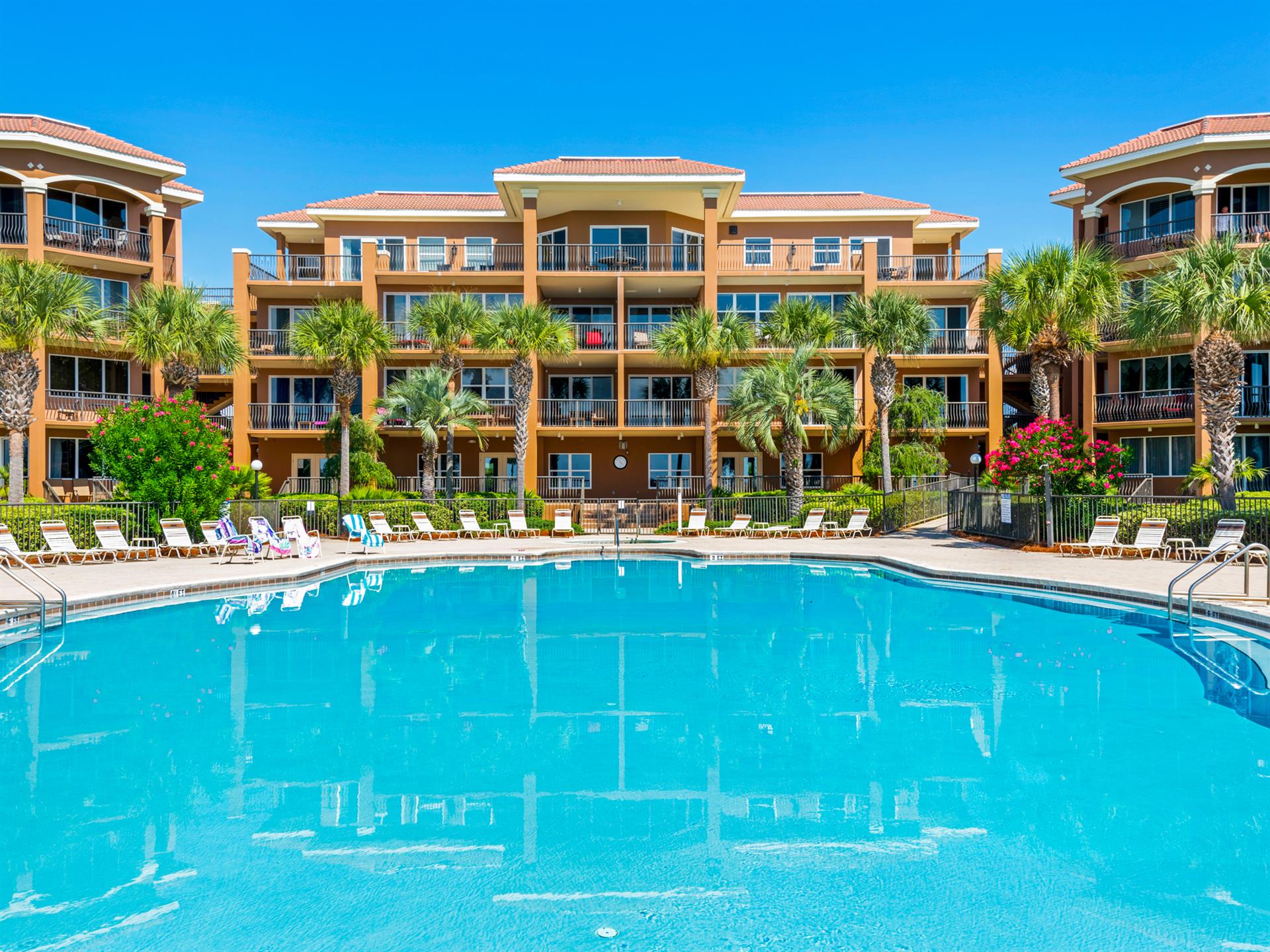 This vacation property features spacious balconies, tropical landscaping and a resort style pool  .