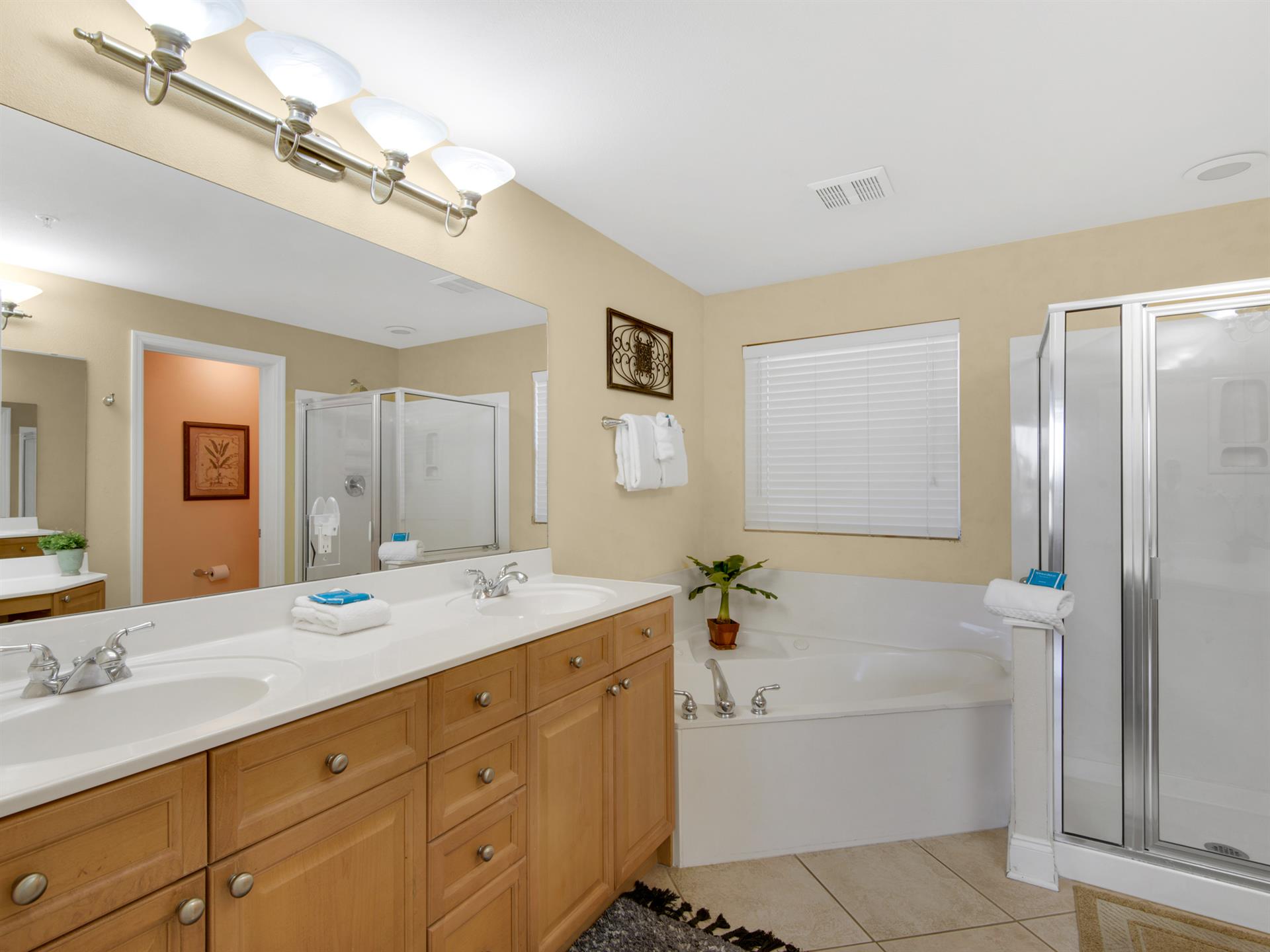 The primary bathroom retreat features a spacious soaking tub, dual vanities and a separate glassenclosed shower.