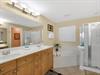 The primary bathroom retreat features a spacious soaking tub, dual vanities and a separate glassenclosed shower.