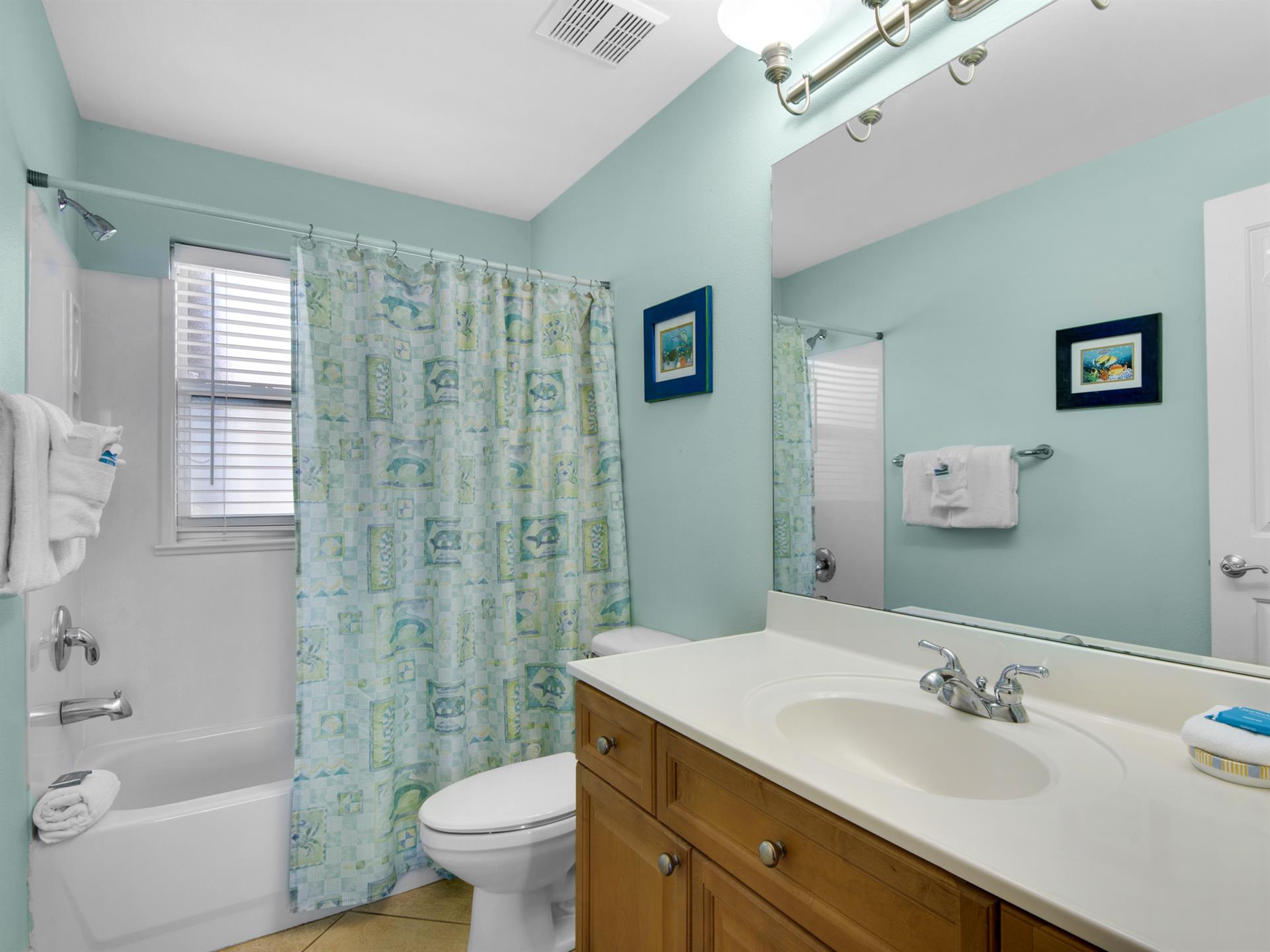 The guest bathroom features a full tubshower, and fresh towels.