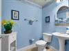 Freshen up in this convenient half bath featuring crisp white fixtures and nautical artwork