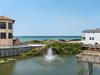 Coastal property featuring direct beach access via boardwalk, tropical landscaping, and stunning ocean views in a serene beachfront community.