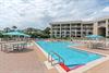 The sparkling outdoor pool is surrounded by comfortable lounge seating and shaded umbrellas, perfect for a refreshing swim or relaxing poolside with a good book.