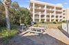 The property building features balconies overlooking lush tropical landscaping and a convenient picnic area with shaded seating—perfect for outdoor relaxation.