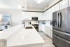Your fully equipped kitchen features gleaming quartz countertops, stainless steel appliances, and bright white cabinetry—perfect for preparing everything from quick breakfasts to memorable vacation di