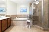 Your spalike bathroom features a soaking tub and walkin shower, perfect for unwinding after exploring. Coastal artwork and warm tones create a soothing retreat.