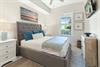 Sink into the plush upholstered bed and let the coastal artwork transport you to peaceful shores. The soft bedding and bright, airy space create your perfect retreat.