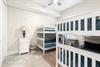 Bright bedroom with two white bunk beds, perfect for the kids to enjoy their own cozy retreat during your family getaway.