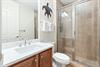 Your private bathroom features a spacious walkin shower, fresh linens, and coastal charm with warm tile accents throughout.