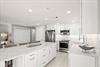 Your modern kitchen is designed for easy meal prep, with sleek white cabinetry and stainless appliances