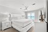 Drift off in this serene coastal bedroom with crisp linens, gentle sea breezes from the ceiling fan, and peaceful ocean glimpses through plantation shutters.