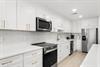 Your bright, modern kitchen awaits with sleek white cabinetry, gold fixtures, and stainless steel appliances—perfect for whipping up meals while you enjoy your getaway.