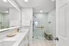 Step into a spalike bathroom with double vanities, bright LED lighting, and a spacious walkin shower featuring elegant gold fixtures and calming tile that invites you to unwind in comfort.
