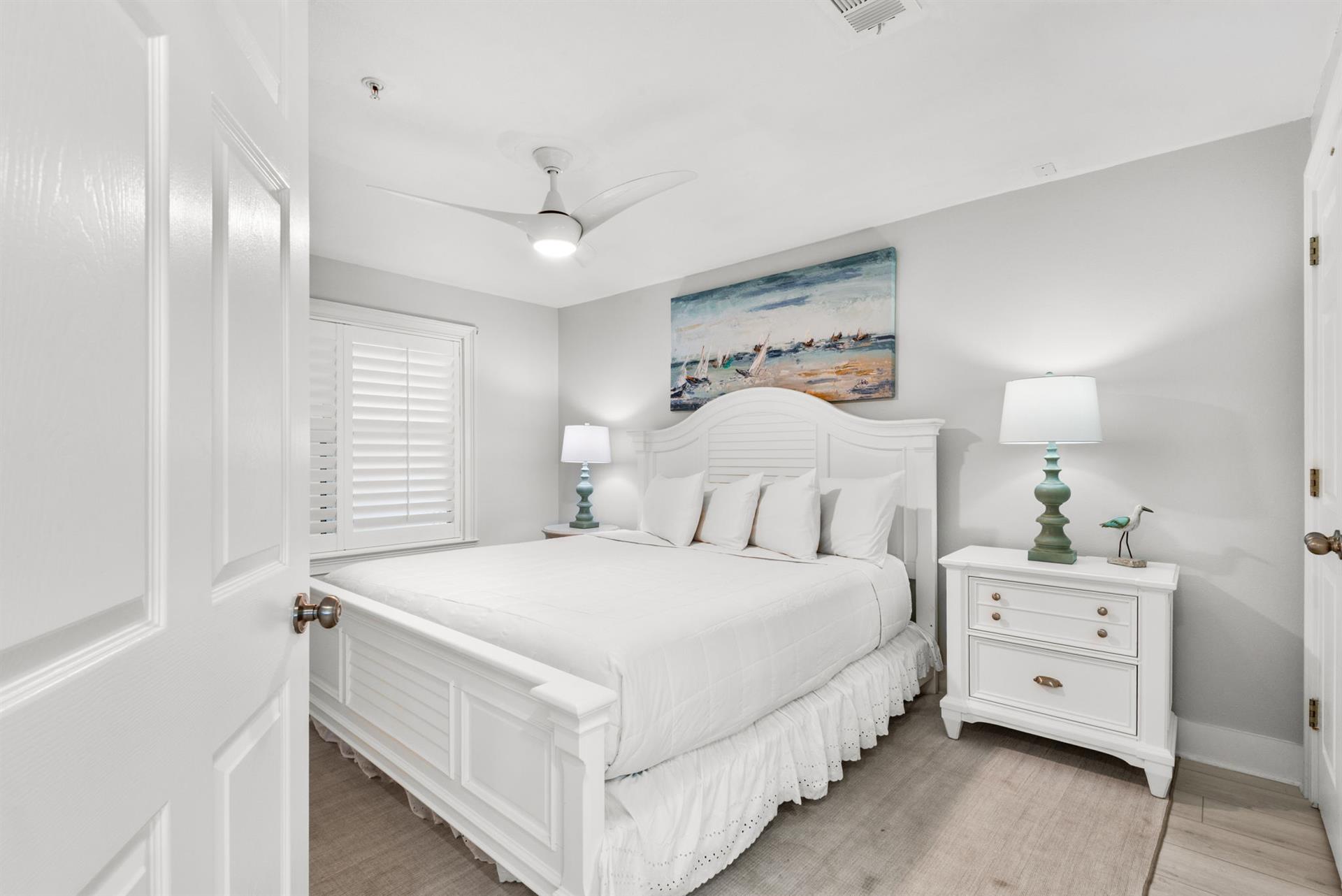 Unwind in your bright bedroom with crisp linens, coastal accents, and a ceiling fan to keep you cool and comfortable.