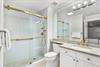 Your modern bathroom features elegant gold fixtures, a spacious walkin shower, and a beautifully lit vanity—the perfect place to refresh after a day of exploring.