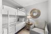 Youll find cozy sleeping arrangements with this spacesaving bunk bed setup, thoughtfully designed with crisp white linens and a comfortable chair for unwinding after your days adventures.