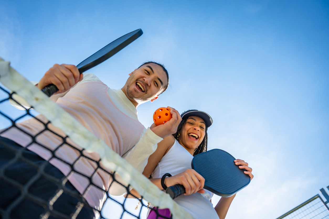 young friends getting ready to play pickleball together while on vacation.