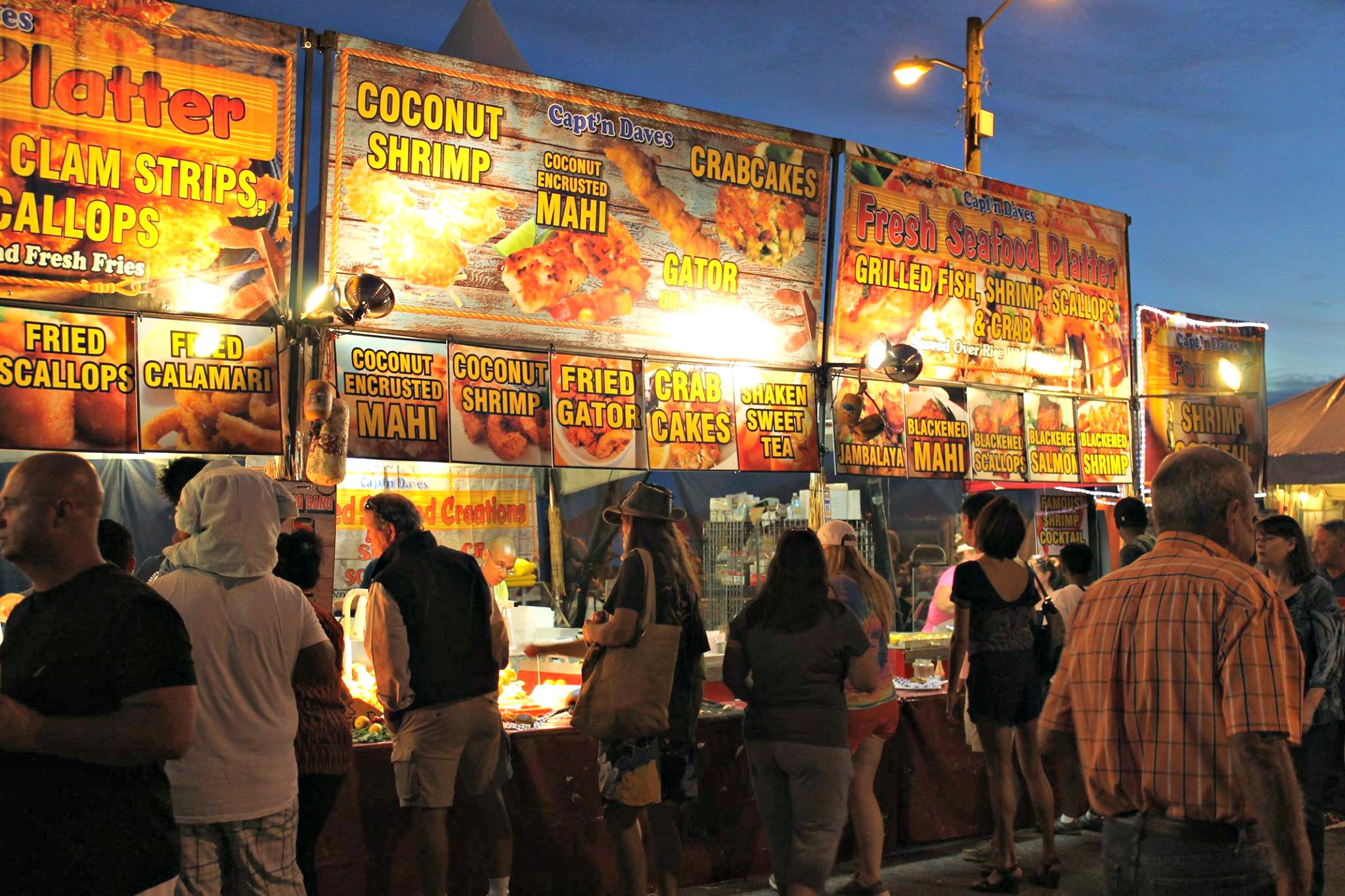 Crowd of festival-goers visiting food booths at the National Shrimp Festival in Gulf Shores, AL.