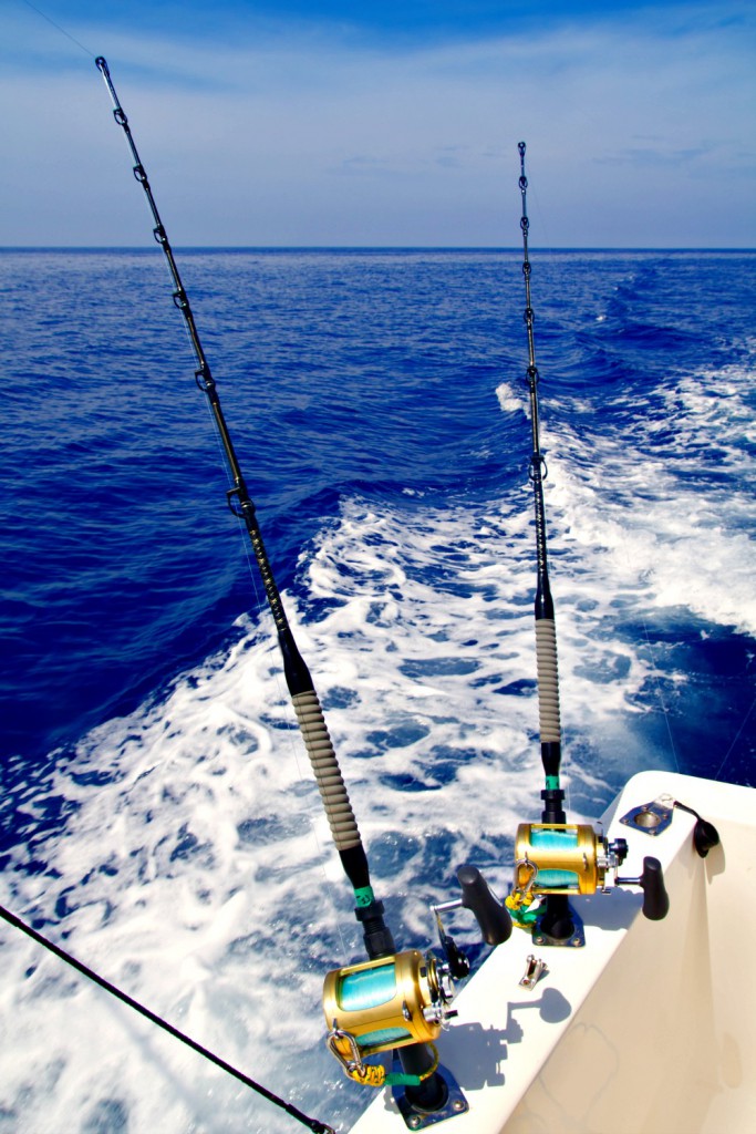 Fishing rods in holders on side of fishing boat for Gulf Coast fishing blog