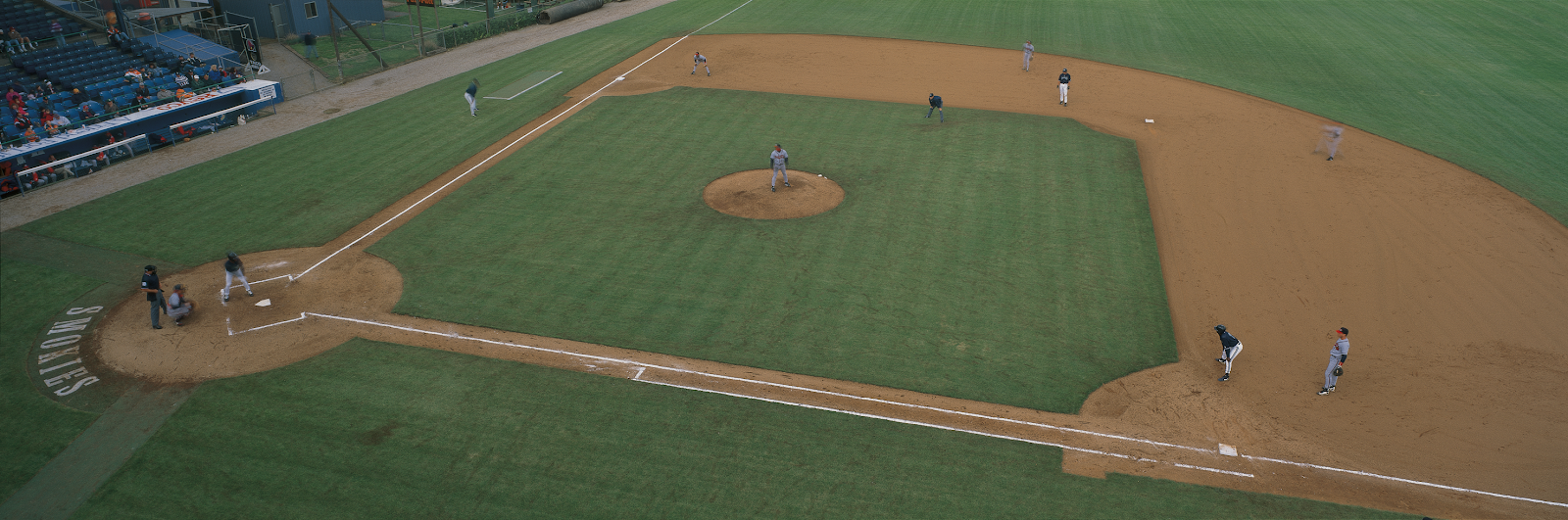 A baseball field with a mound and dirt

Description automatically generated