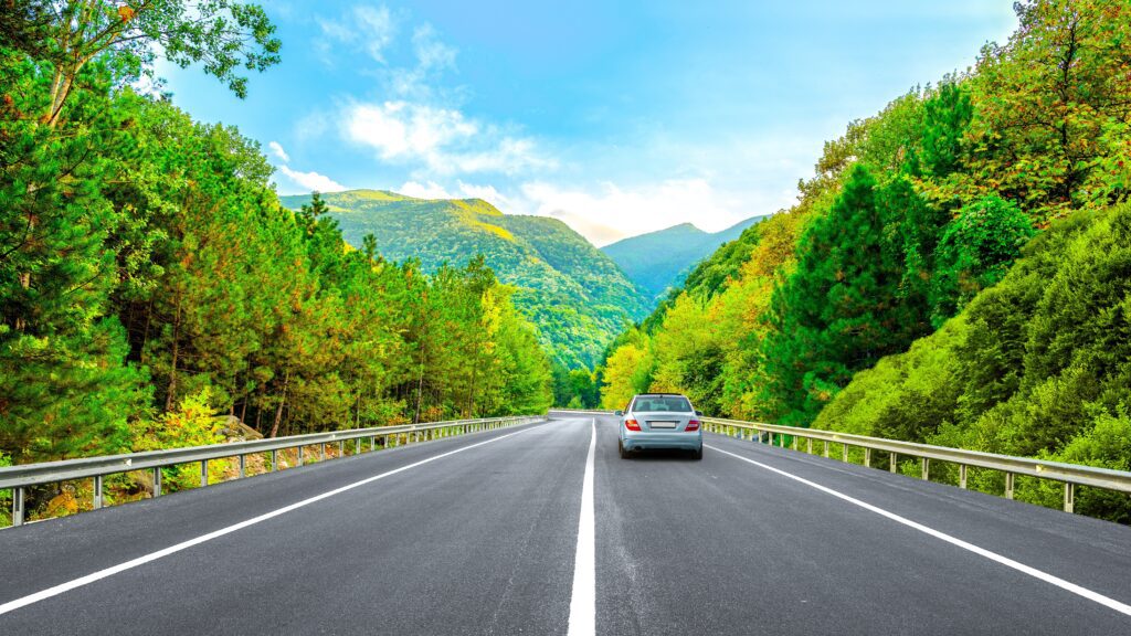 Car driving down a scenic mountain road