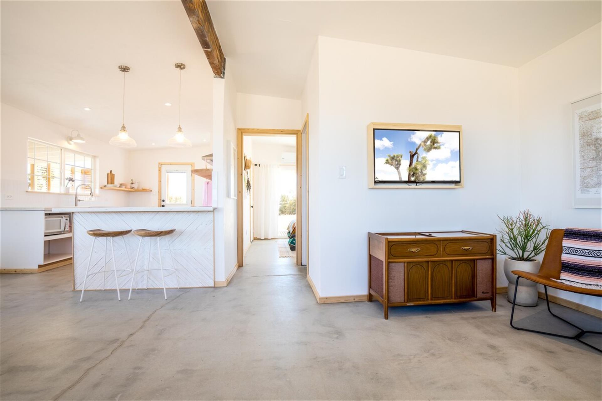 The open and airy living room comes with a vintage 1950s record player and smart tv