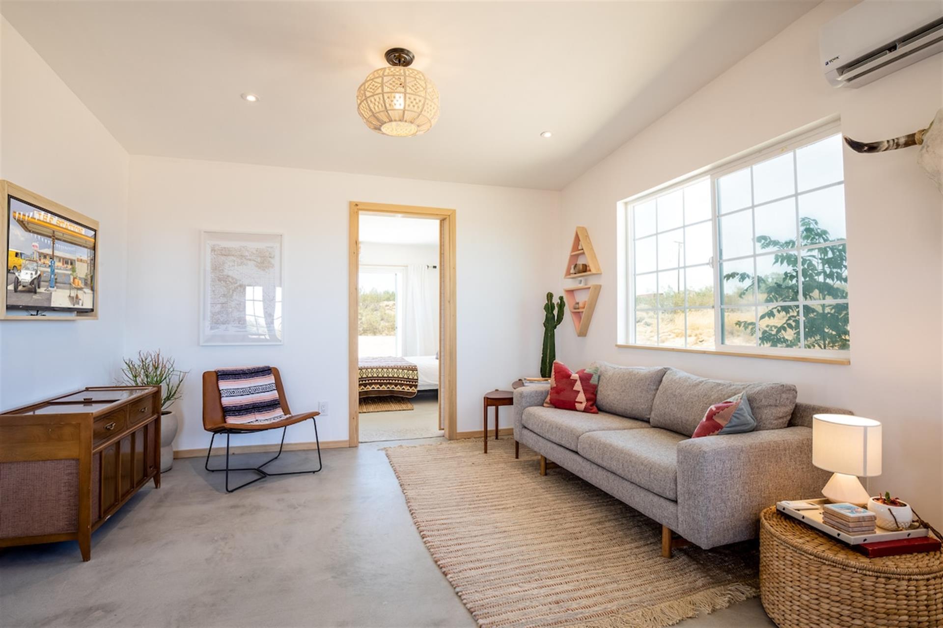 The living room features comfortable seating, a vintage record player, and smart tv