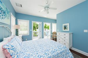 Bedroom includes dresser, bedside lighting and ceiling fan.