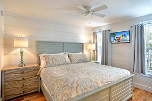 Comfy king bed with flat screen TV and bedside lighting.