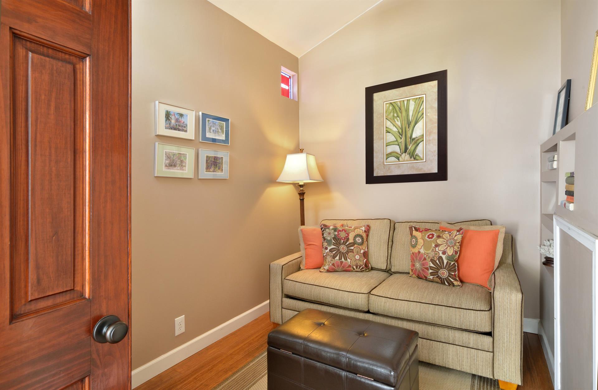 A small bonus room with a builtin bookcase and a love seat.