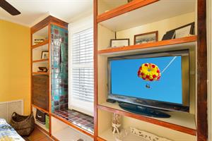 Bedroom includes flat screen TV and ceiling fan.