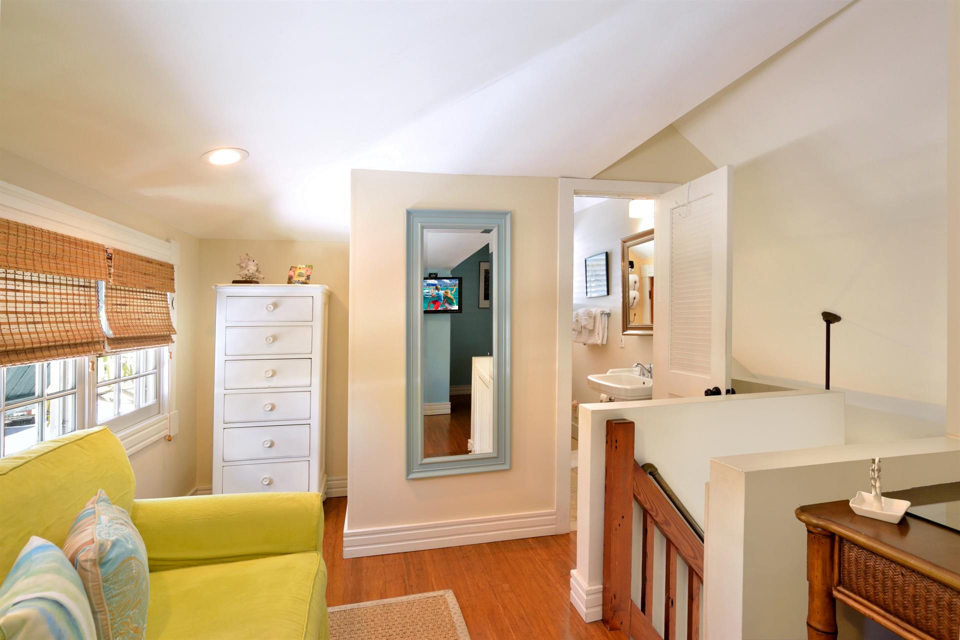 Primary bedroom includes dresser and full length mirror.