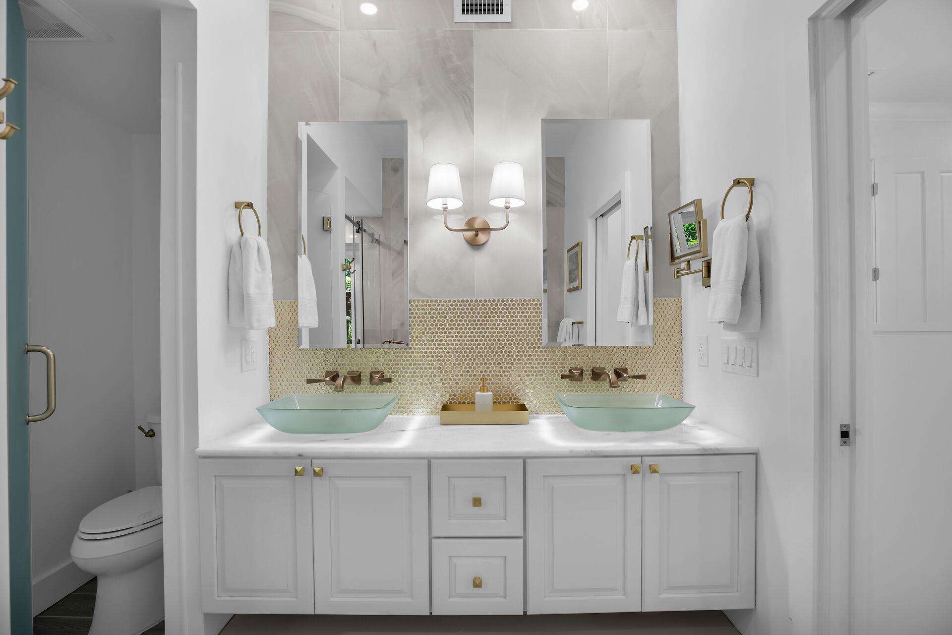 Double vessel sinks with gold accents in primary ensuite.